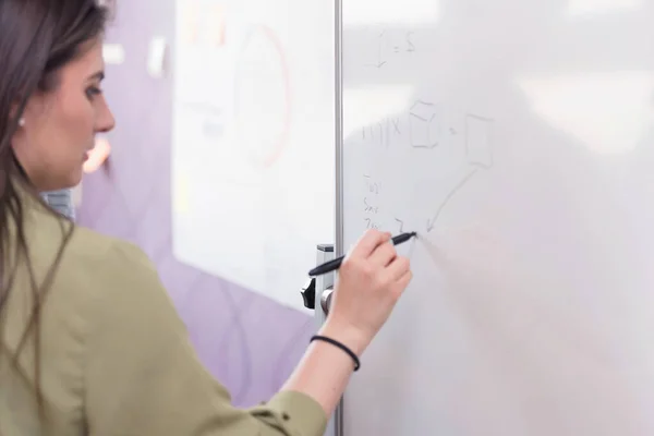 Young college female student writting on the chalkboard during a — Stock Photo, Image