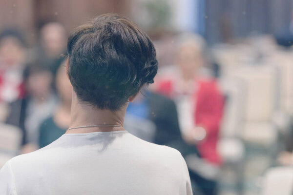 Beautiful business woman with microphone in her hand speaking at