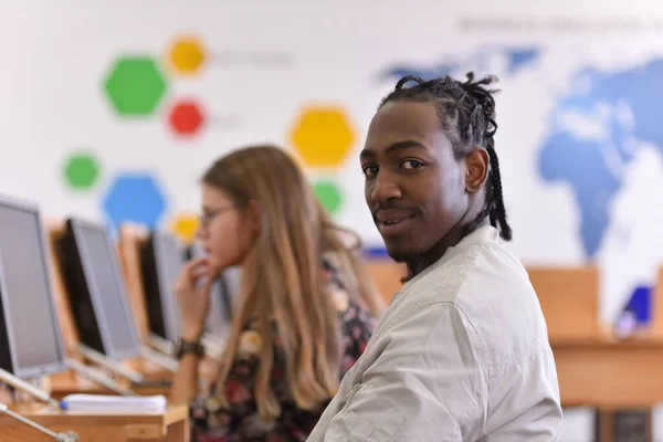 Two young students looking at the camera and smiling. Learning inside the modern classroom. Education concept.