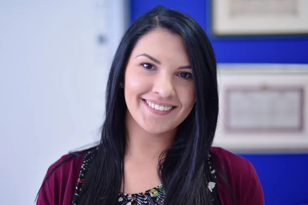 Hermosa estudiante en el campus universitario interior. Sonriendo hacia la cámara. —  Fotos de Stock