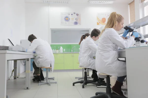 Gruppo di giovani scienziati di laboratorio che lavorano in laboratorio con test tu — Foto Stock