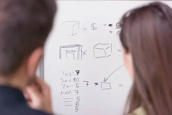 Two young college male and female students writting on the chalk — Stock Photo, Image