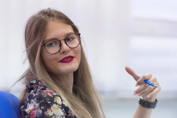 Universitaria estudiante en clase se sienta en su escritorio girando a s —  Fotos de Stock