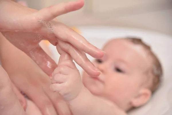 Pretty three months baby girl taking a bath by her mother at home, european child. — Stock Photo, Image
