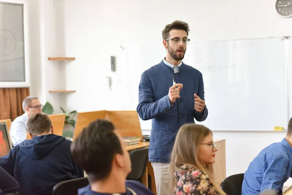 Mužský profesor vysvětlit lekci studentům a komunikovat s nimi — Stock fotografie