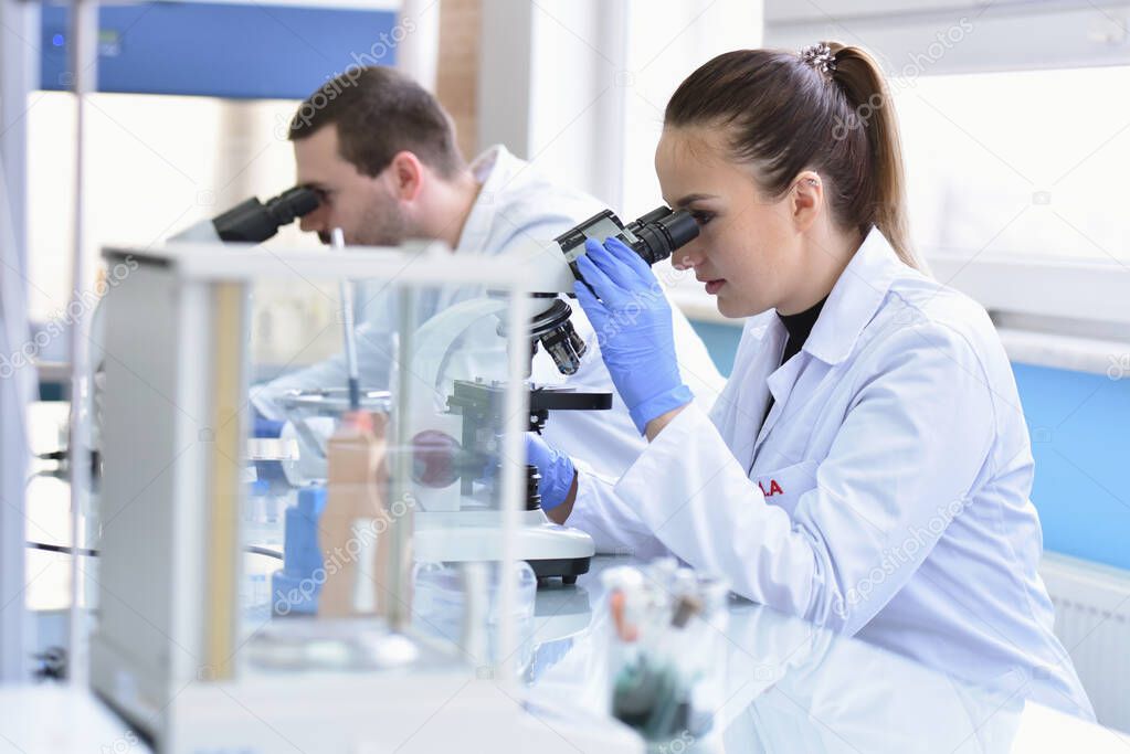 Two Young Female and male Laboratory scientists working at lab w