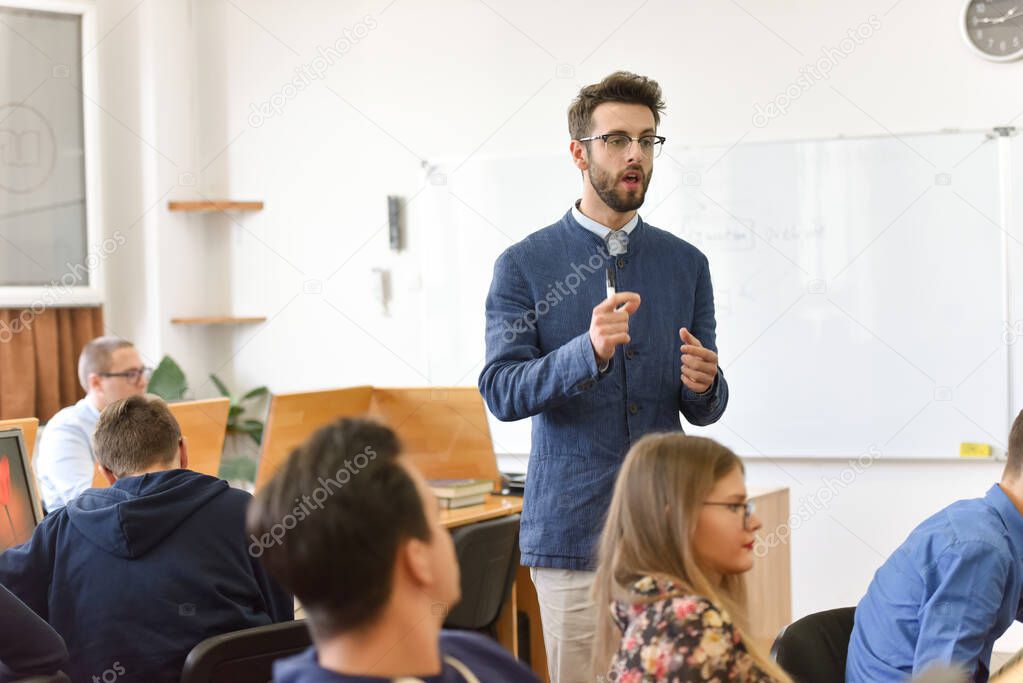 Male professor explain lesson to students and interact with them