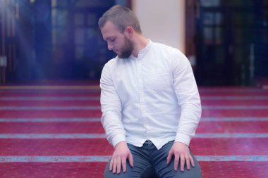 Genç, dindar, Avrupalı Müslüman adam bu güzel adamın içinde dua ediyor.