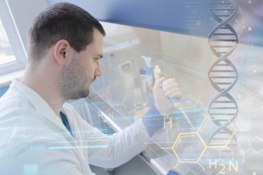 Laboratuvarda test tüpleriyle çalışan genç bir bilim adamı.