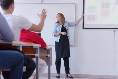Bayan profesör öğrencilere açıkla ve onlarla iletişim kur.