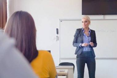 Çekici kadın profesör öğrencilere ve öğrencilere ders veriyor.