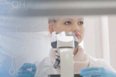 Laboratuvarda test tüpleriyle çalışan genç kadın laboratuvar bilim adamı.