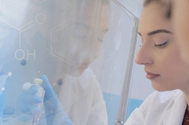 Laboratuvarda deney tüpleriyle çalışan iki genç bilim adamı...