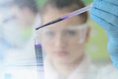 Laboratuvarda test tüpleri ve mikroskopla çalışan iki genç kadın ve erkek bilim adamı.