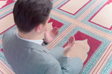 Dindar Müslüman adam caminin içinde dua ediyor..