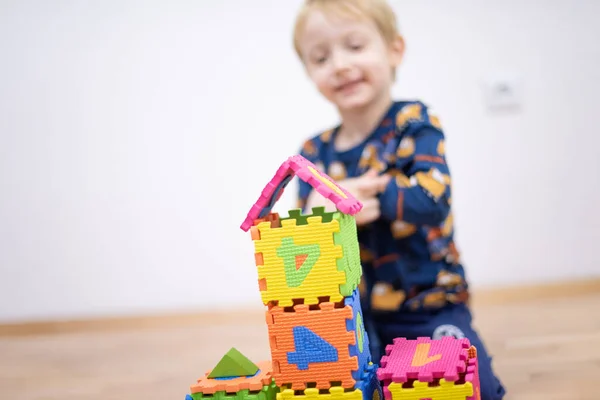 Criança pré-escolar brincando com blocos de brinquedos coloridos. Miúdo a brincar — Fotografia de Stock