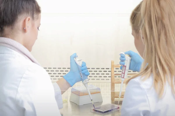 Duas jovens cientistas de laboratório trabalhando no laboratório com teste — Fotografia de Stock