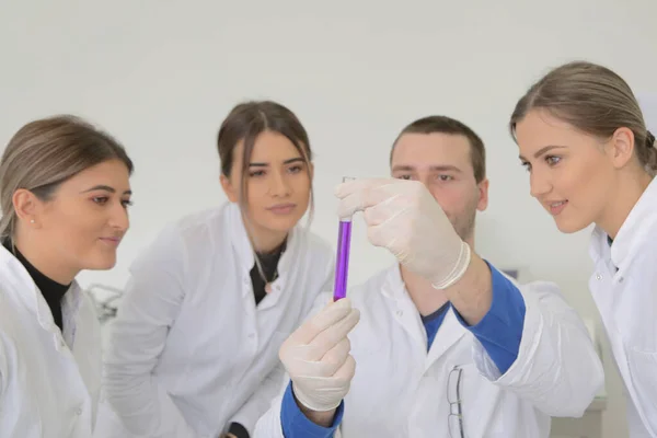 Gruppe junger Laboranten arbeitet im Labor mit Test tu — Stockfoto