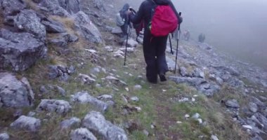 Bir grup yürüyüşçü sisli bir sabahta dağda yürüyorlar.