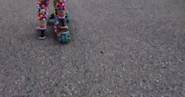 Küçük çocuk güneşli bir yaz gününde şehir parkında scooter sürmeyi öğreniyor. Patenli tatlı anaokulu kızı.. 