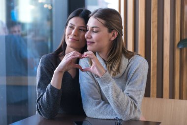 Bir kafede buluşan lezbiyen bir çift. İki eşcinsel kız arkadaş el ele tutuşup bir barda flört ediyorlar. Dokunsal duygular. Lgbt.