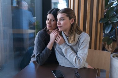 Bir kafede buluşan lezbiyen bir çift. İki eşcinsel kız arkadaş el ele tutuşup bir barda flört ediyorlar. Dokunsal duygular. Lgbt.