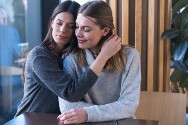 Bir kafede buluşan lezbiyen bir çift. İki eşcinsel kız arkadaş el ele tutuşup bir barda flört ediyorlar. Dokunsal duygular. Lgbt.