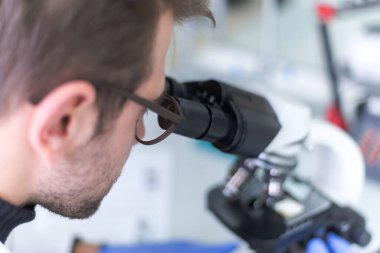 Laboratuvarda test tüpleri, mikroskop, test veya araştırma ile çalışan genç erkek laboratuvar bilim adamı. Bilim, kimya, biyoloji, tıp ve insan konsepti..