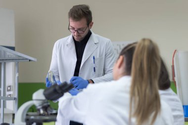 Laboratuvarda test tüpleri, test veya araştırma laboratuvarında çalışan bir grup bilim adamı. Bilim, kimya, biyoloji, tıp ve insan kavramı.