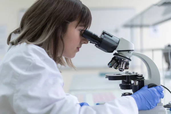 在实验室工作的年轻女性实验室科学家 从事临床实验室的试管 显微镜 测试或研究 医学和人的概念 — 图库照片
