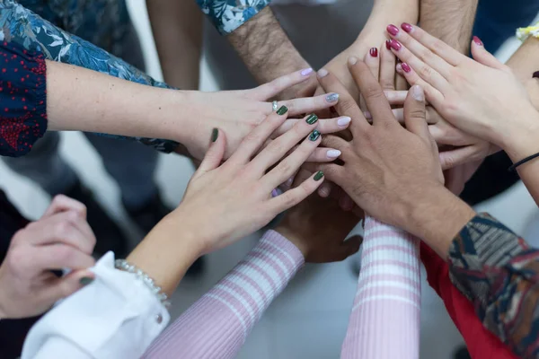 Multiracial Group of college students with Hands in Stack, Teamwork