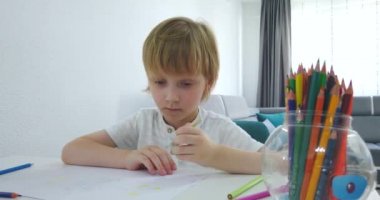 Tabletli ve çizim aletli beş yaşında bir çocuk. Okul ödevi yapan dijital tablet ve defterle çevrimiçi eğitim mesafesi.