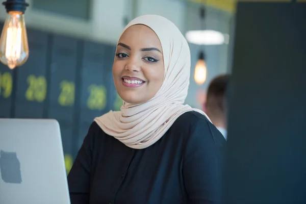 ヒジャーブを着用し オフィスのコンピュータで働いているイスラム教徒のビジネス女性 カメラを見て笑っているヒジャーブ州のかなりアフリカの女性 職場と多民族関係の概念 — ストック写真