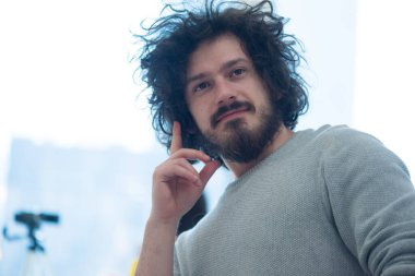 Yapılan işten memnun. Ofisinde çalışırken dizüstü bilgisayarda çalışan mutlu genç adam.