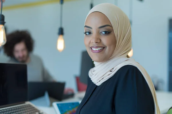 穆斯林女商人头戴头巾 在办公室的电脑上工作 漂亮的非洲女人 头戴头巾 看着相机笑着 工作场所和多族裔关系的概念 — 图库照片