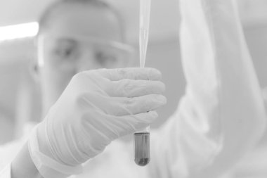 Genç kadın bilim adamı laboratuarda deneyler yapıyor.