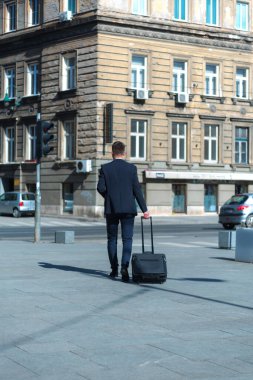 Ofis dışındaki genç iş adamının portresi. Toplantı Konsepti. Adam yürüyor, kahve içiyor, ofise gidiyor ya da iş toplantısına gidiyor..