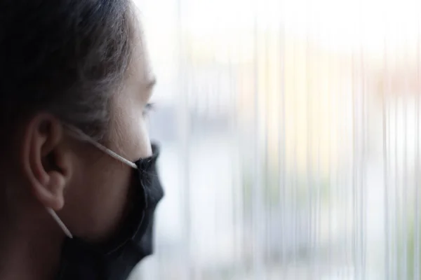 Młoda Kobieta Masce Medycznej Zostaje Domu Kwarantannę Wygląda Przez Okno — Zdjęcie stockowe