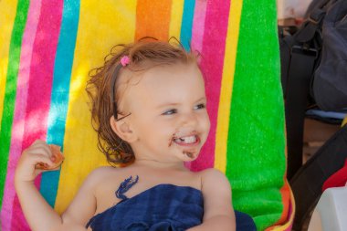 Kumsalda çörek yiyen bir bebek, tarlanın sığ derinliğine dikkat edin.