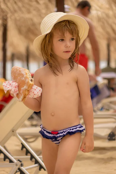 Meisje Eet Een Donut Het Strand — Stockfoto