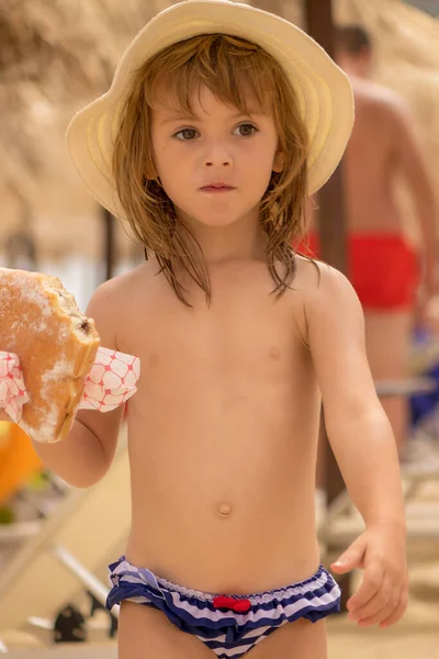 Meisje Eet Een Donut Het Strand — Stockfoto