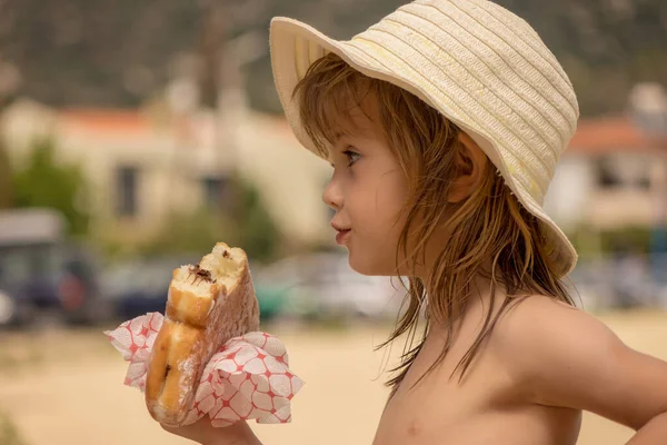 Meisje Eet Een Donut Het Strand — Stockfoto