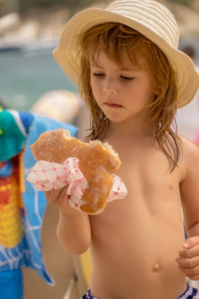Meisje Eet Een Donut Het Strand — Stockfoto