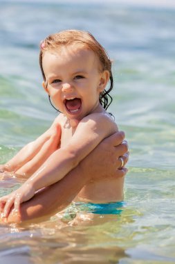 Bir çocuk denizde yüzmeyi öğrenir, yüzeysel alan derinliğine dikkat edin.