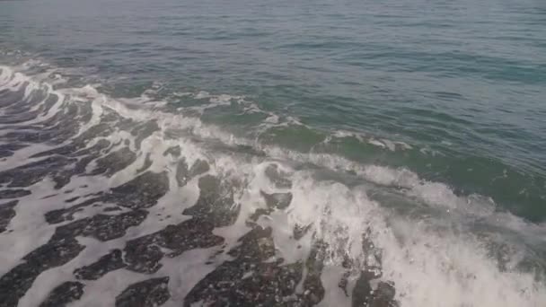 上から撮影された空のビーチで波がクラッシュするのを閉じて スローモーション — ストック動画