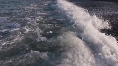 Yukarıdan çekilen boş bir sahile çarpan dalgaların yakın çekimi, yavaş çekim.