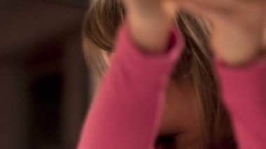 Okul masasında aydınlanmış bir küreyle resim çizen ve tablet izleyen sevimli küçük kız, seçici bir odak noktası.