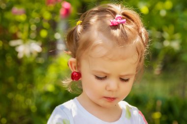 Çocuk ve kiraz, doğadaki küpe gibi, derin alan derinliğine dikkat edin.