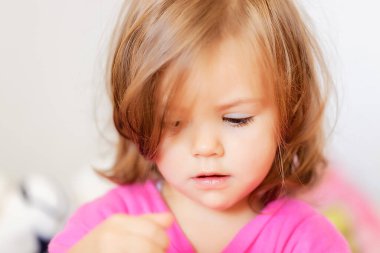 Pembe elbiseli bir çocuğun portresi, tarlanın sığ derinliğine dikkat edin.