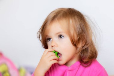 Ağzında oyuncak olan bir çocuğun portresi, yüzeysel alan derinliğine dikkat edin.